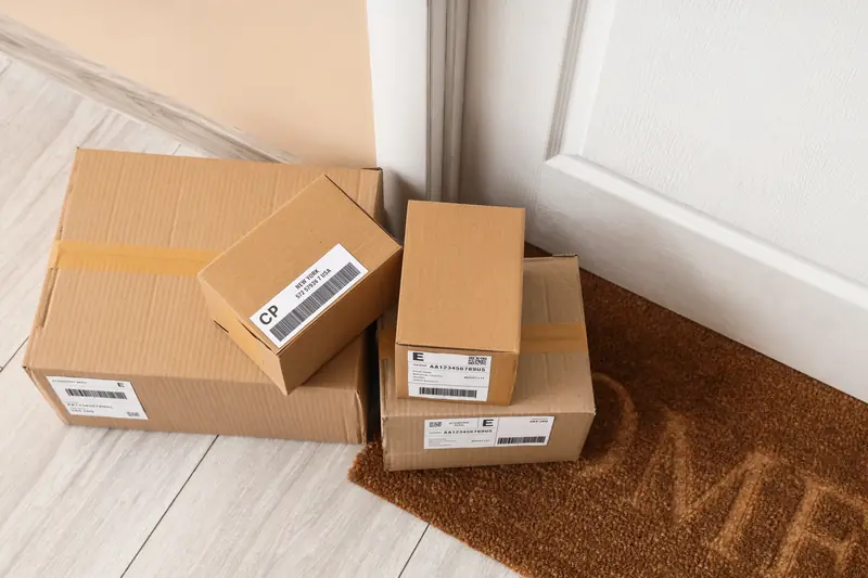 Mehrere Pakete stehen auf dem Boden vor einer Wohnungstür